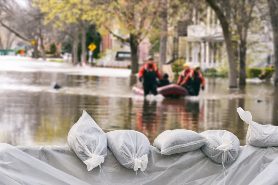 Sandbags in a flood with flooded buildings in background